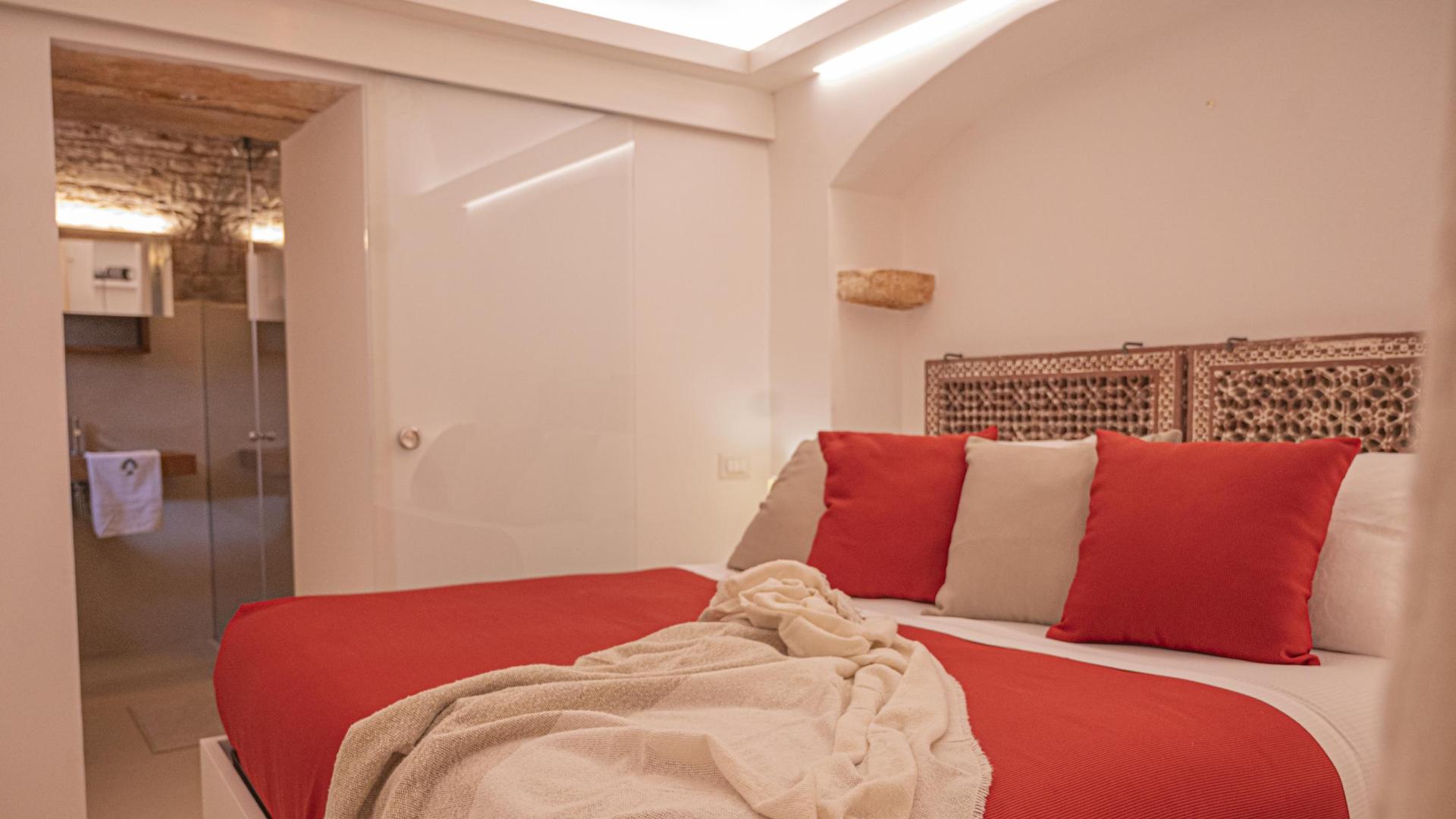 Cozy bedroom with red decor and attached bathroom.