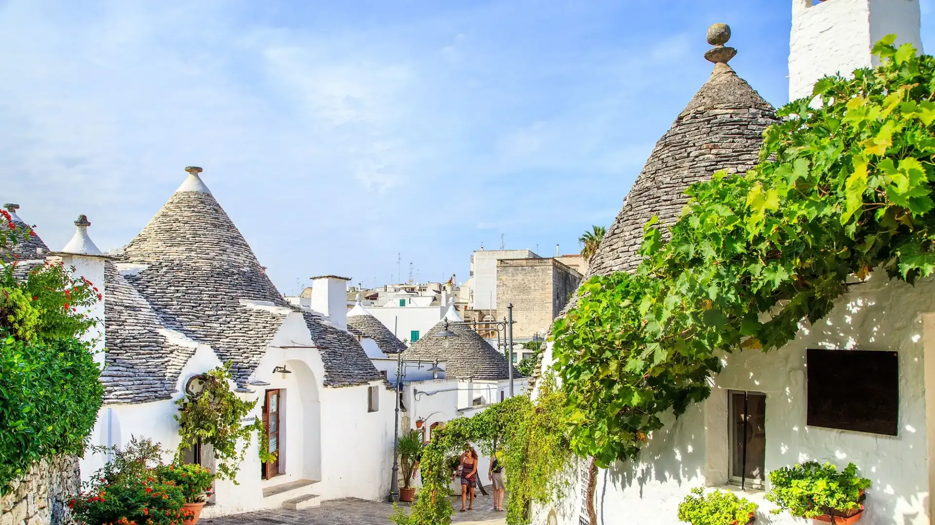 Charming white trulli with conical roofs in Alberobello, Italy.