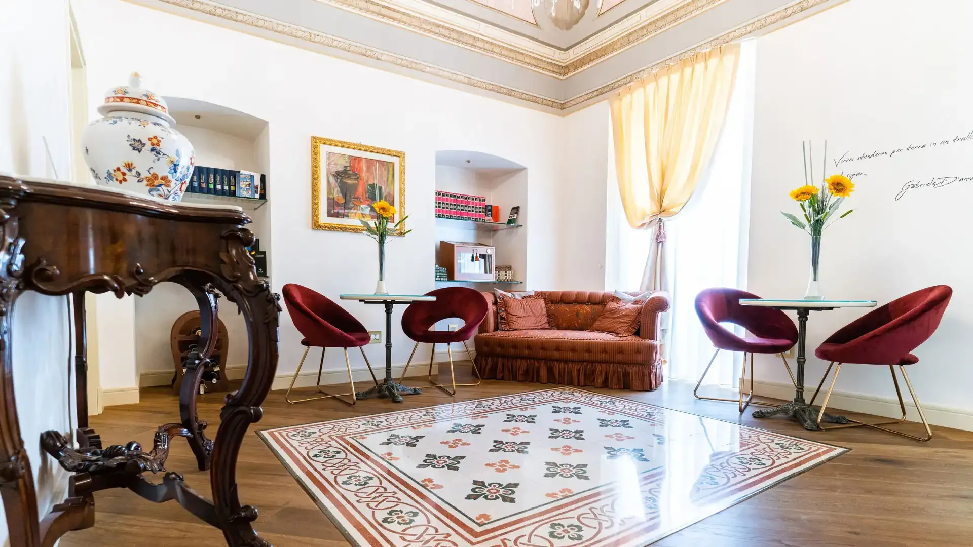 Salon élégant avec des meubles anciens, des chaises rouges et des décorations florales.