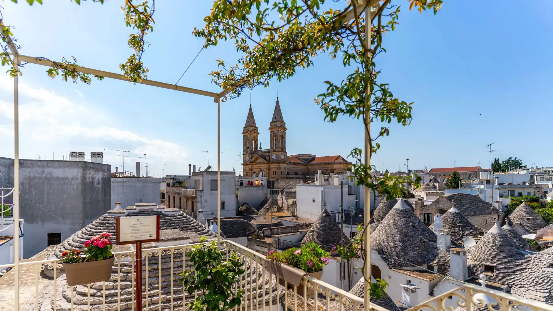 Vue panoramique sur les trulli et une église au loin.