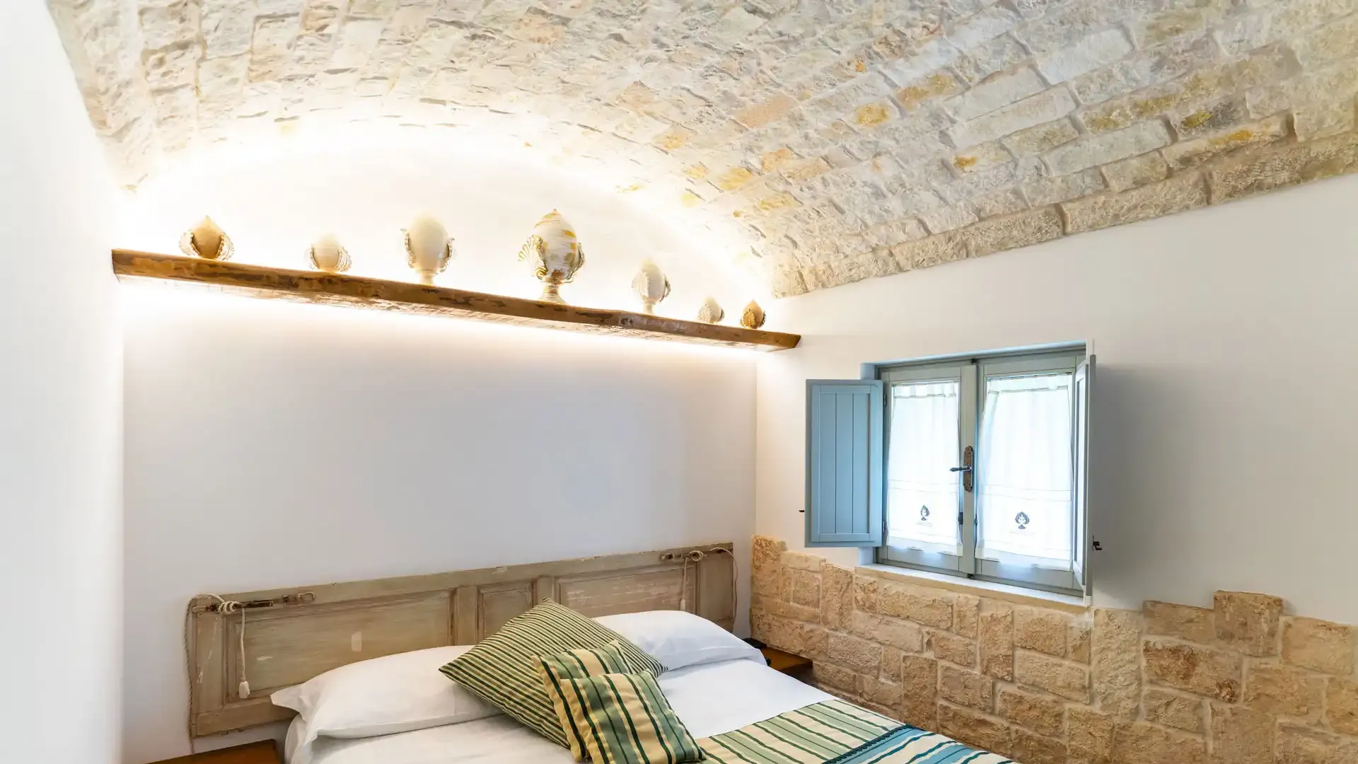 Chambre confortable avec plafond en pierre et décorations rustiques.