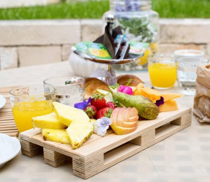 Petit-déjeuner en plein air avec fruits frais, jus et pain.