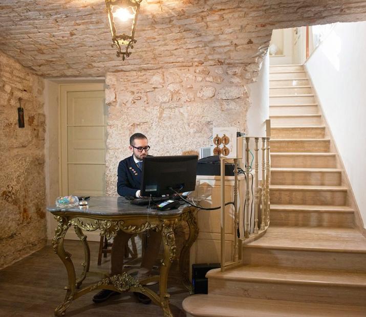 Office with stone walls, elegant desk and wooden staircase.