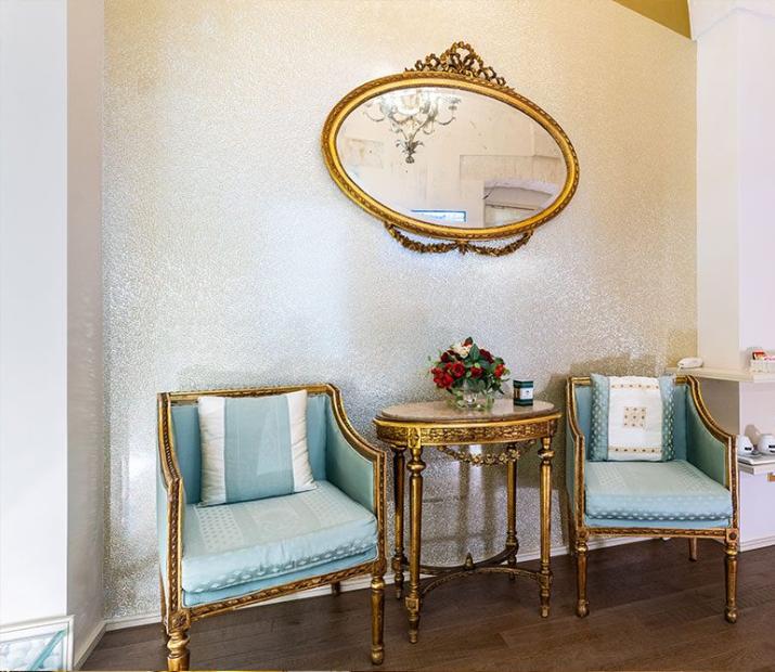 Coin salon élégant avec miroir doré et meubles raffinés.