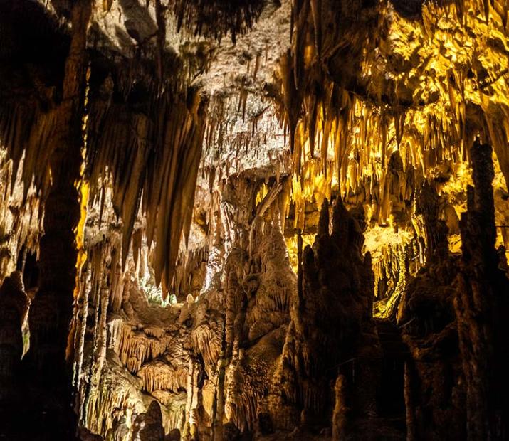 Grottes illuminées avec stalactites et stalagmites, un fascinant spectacle naturel souterrain.
