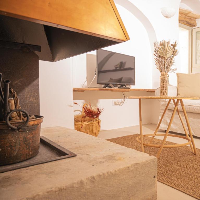 Cozy living room with fireplace, beige sofa, and natural decorations.