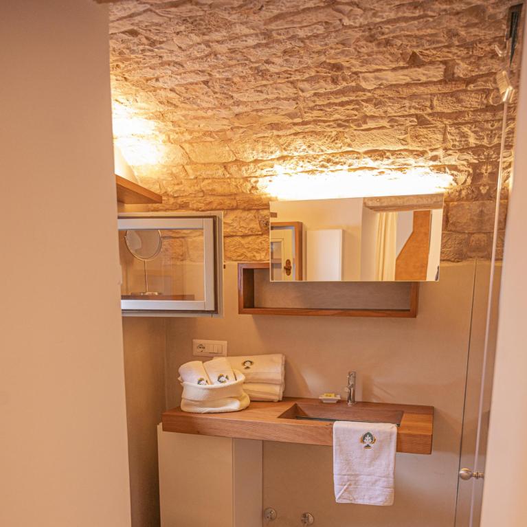 Salle de bain chaleureuse avec plafond en pierre et mobilier moderne.