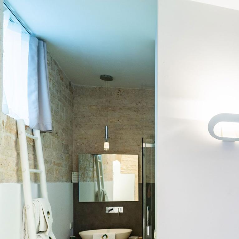 Salle de bain moderne avec lavabo, miroir et échelle à serviettes.