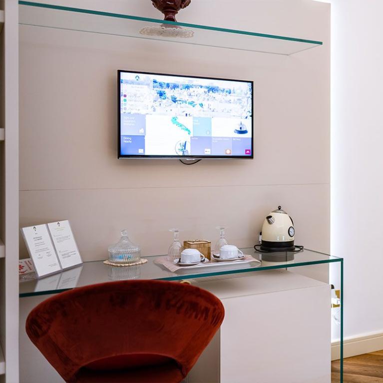 Refreshment corner with TV, kettle, and cups in a modern room.