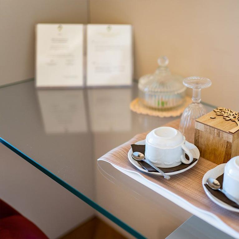 Two coffee cups with glasses and a decorative box on a table.