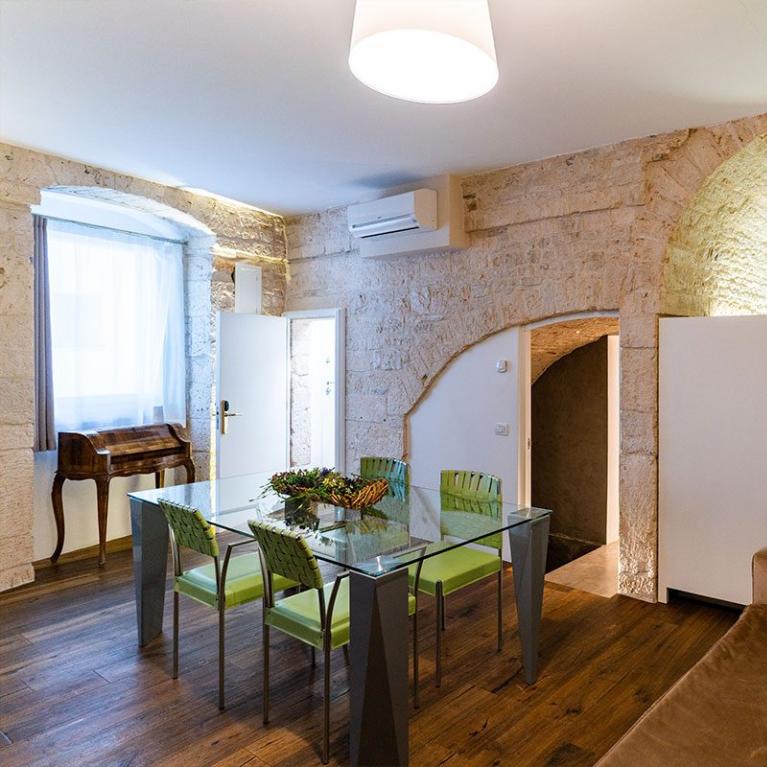 Salon confortable avec cuisine dans un cadre rustique avec des murs en pierre.